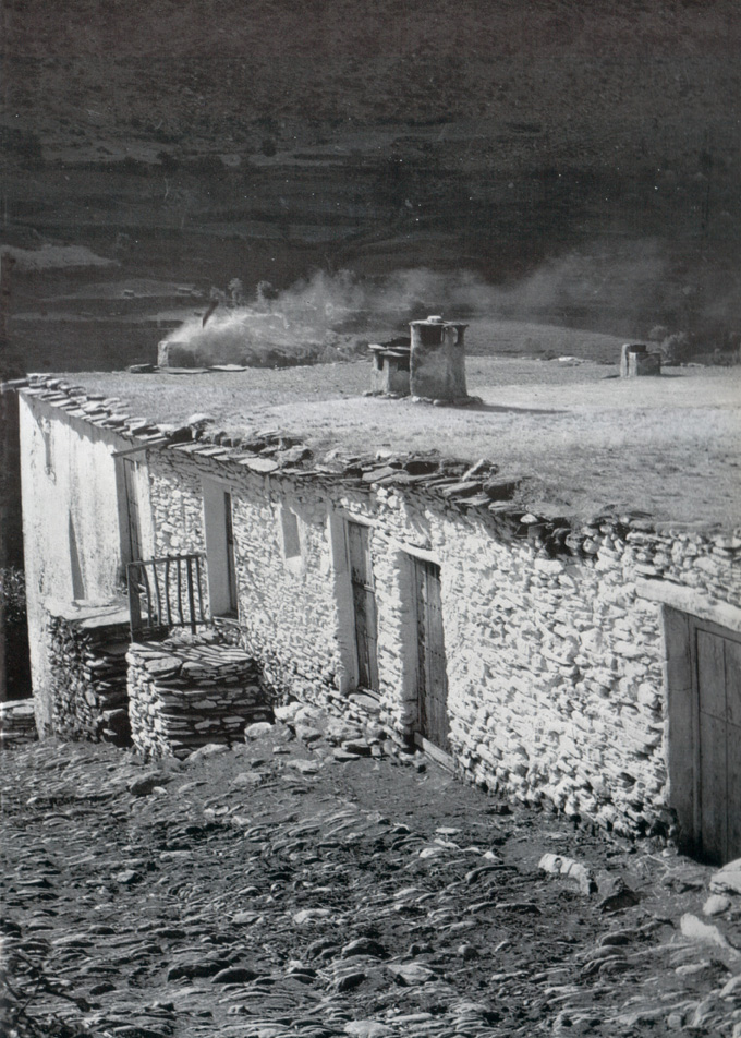 Vivienda alpujarreña con muros encalados, terrado de launa y chimenea tradicional integrada en la arquitectura local